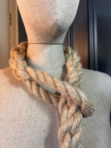A thick, twisted rope necklace displayed on a mannequin.